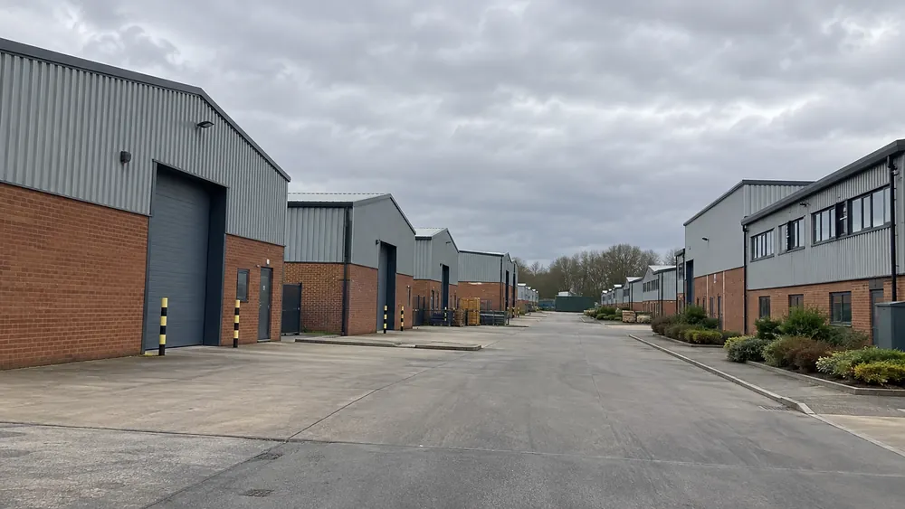 Commercial warehouse units with a wide access road in an industrial estate
